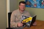 man sitting at a table holding a report