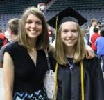 smiling female grad wearing gold cords posing with sister