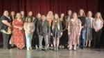 group of 16 people standing on theatre stage