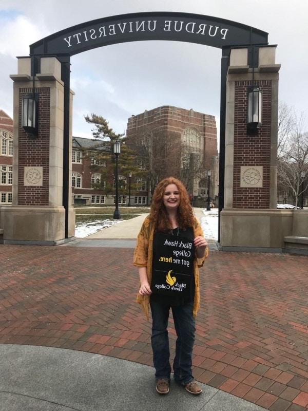 student holding a sign that says Black Hawk College got me here