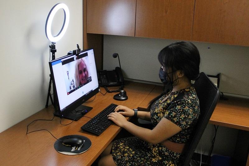 woman sitting at a desk using a computer to try out the interview equipment at 职业生涯 Services