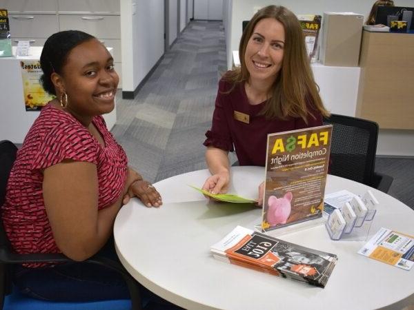 Financial Aid director and student sitting at a table smiling