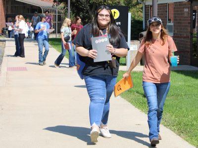 smiling students walking outdoors at East Campus