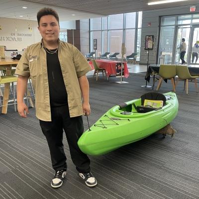 student with kayak in upper lobby of Building 1