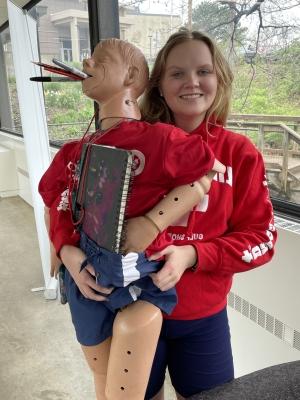 student holding mannequin with school supplies